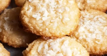 Delicious chewy coconut cookies on a wooden surface