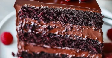 Delicious Chocolate Raspberry Truffle Cake topped with fresh raspberries and chocolate shavings.