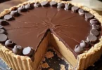 Giant Reese's Peanut Butter Cup Pie topped with chocolate and peanut butter.