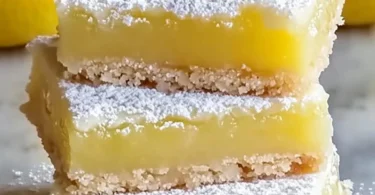 Delicious limoncello bars served on a plate, garnished with lemon zest.