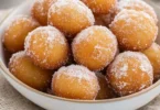 Delicious mini donut bites served on a plate with powdered sugar