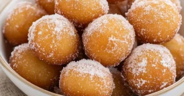 Delicious mini donut bites served on a plate with powdered sugar