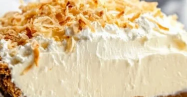 Delicious no bake coconut cream pie topped with whipped cream and coconut flakes.