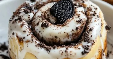 Delicious homemade Oreo Cinnamon Rolls topped with cream and crushed Oreos