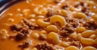 Delicious one-pot macaroni cheeseburger soup topped with cheese and spices.
