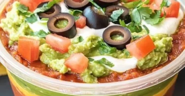 Delicious 7 layer dip served in a bowl with colorful layers