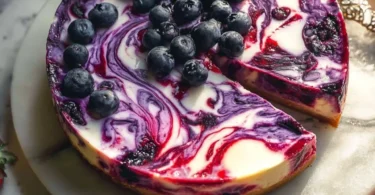 Delicious Berry Swirl Cheesecake topped with fresh berries