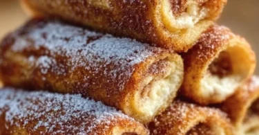 Cinnamon roll french toast roll-ups served with syrup and berries on a plate