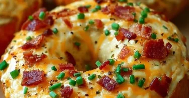Freshly baked creamy bacon cheddar bagels with melted cheese and crispy bacon
