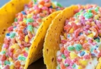 Fruity Pebbles cheesecake tacos served on a colorful plate