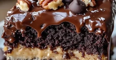 Slice of German Chocolate Poke Cake with coconut and pecan topping