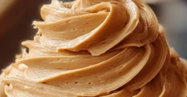 Delicious homemade peanut butter frosting spread on a chocolate cake