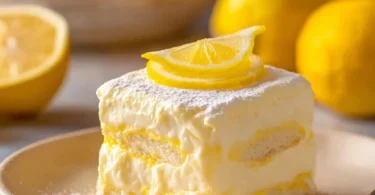 Delicious Lemon Tiramisu dessert topped with lemon zest and served in a clear glass.