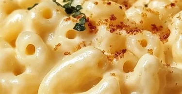 Creamy mac and cheese topped with cream cheese in a delicious dish.