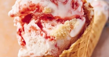 No churn strawberry cheesecake ice cream in a bowl with fresh strawberries