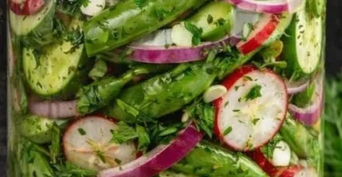 Colorful jar of pickled snap pea salad showcasing vibrant greens and spices.