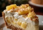 Delicious slice of Pineapple Cream Cheese Pie on a plate garnished with pineapple.