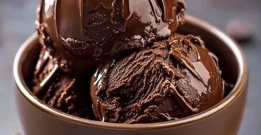 Rich homemade chocolate ice cream in a bowl with chocolate shavings on top.