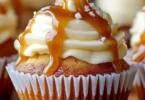 Salted caramel cream cheese cupcakes topped with caramel drizzle and sprinkles
