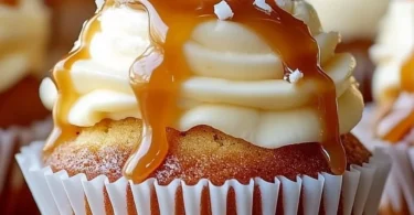 Salted caramel cream cheese cupcakes topped with caramel drizzle and sprinkles