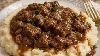 Slow cooker beef served with creamy mashed potatoes on a plate