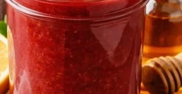 Homemade slow cooker strawberry butter served on a slice of bread.
