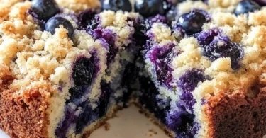 Sour Cream Blueberry Coffee Cake with blueberries on a plate