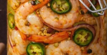 Sweet heat jalapeño pickled shrimp in a serving dish garnished with herbs