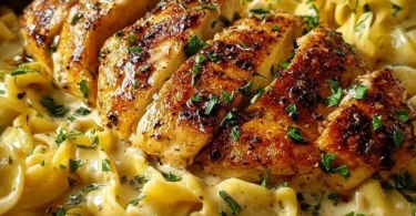 A plate of Chicken with Buttered Noodles, served with parsley garnish.