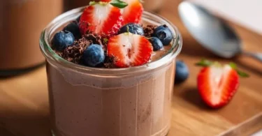 A bowl of creamy Chocolate Protein Pudding topped with chocolate shavings.