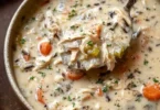 Creamy crockpot chicken wild rice soup served in a bowl with fresh herbs