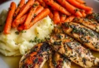 Garlic Herb Chicken served with creamy mashed potatoes and glazed carrots