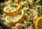 Bowl of Greek Lemon Rice garnished with fresh parsley and lemon wedges