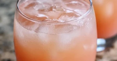 Iced Guava White Tea Lemonade in a clear glass with lemon slices