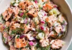 Delicious and healthy salmon salad served in a bowl with fresh vegetables.