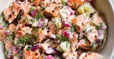 Delicious and healthy salmon salad served in a bowl with fresh vegetables.