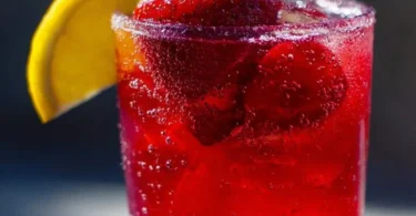Refreshing hibiscus tea strawberry-lemonade refresher in a glass with ice.