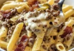 Delicious plate of cheesy beef and bacon pasta with herbs garnishing