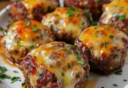 Cheesy stuffed meatloaf bites served on a plate, ready to enjoy.