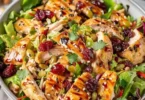 A vibrant Chicken Coleslaw Salad served in a bowl with fresh vegetables.