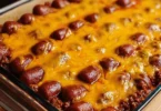 Delicious Chili Dog Casserole topped with cheese and served in a baking dish