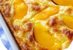 Peaches & Cream Cottage Cheese Breakfast Bake in a baking dish topped with fresh peaches