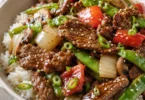Delicious pepper steak served with colorful vegetables on a plate