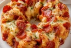 Savory pepperoni pizza monkey bread with melted cheese and pepperoni slices.
