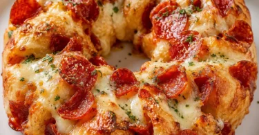 Savory pepperoni pizza monkey bread with melted cheese and pepperoni slices.