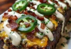 Smoky jalapeno popper meatloaf topped with a creamy ranch drizzle